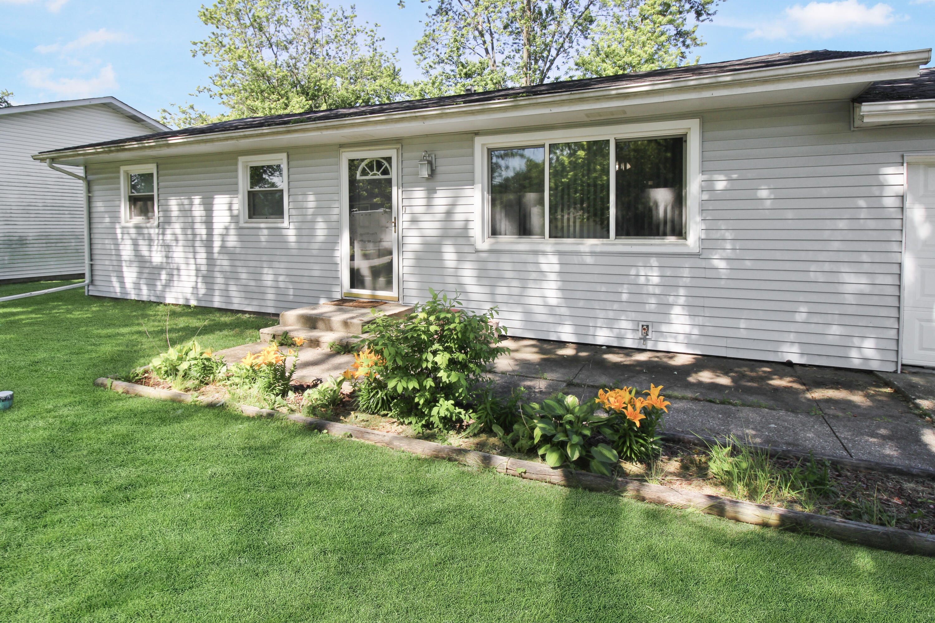 7714 Wallace Street Merrillville, IN 46410 - Photo 1 of 14 a front view of a house with a yard and potted plants