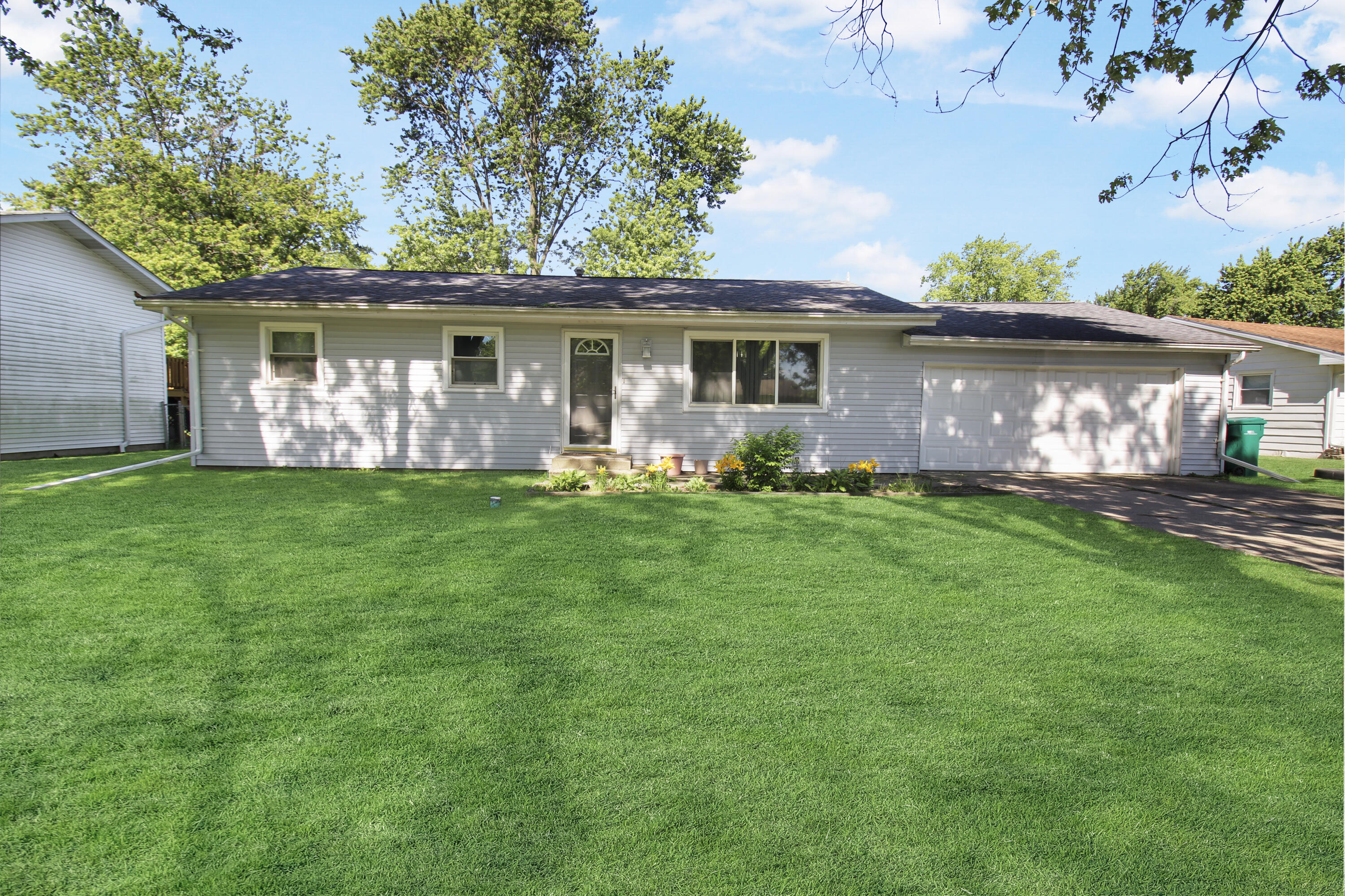 7714 Wallace Street Merrillville, IN 46410 - Photo 2 of 14 a front view of a house with a garden and yard