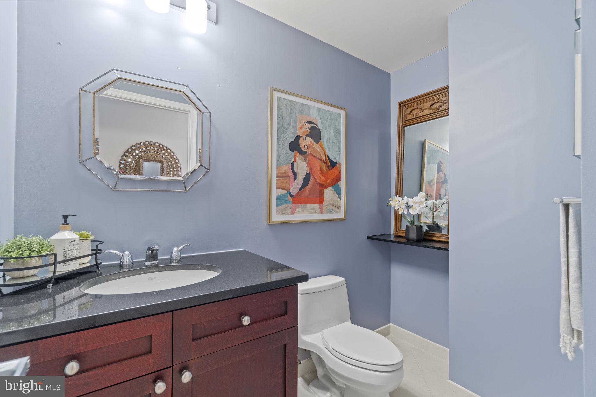 675 E Street Northwest, Unit 500 Washington, DC 20004 - Photo 12 of 52 a bathroom with a toilet a sink and mirror