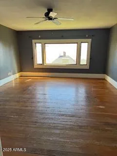 a view of a livingroom with wooden floor and a ceiling fan