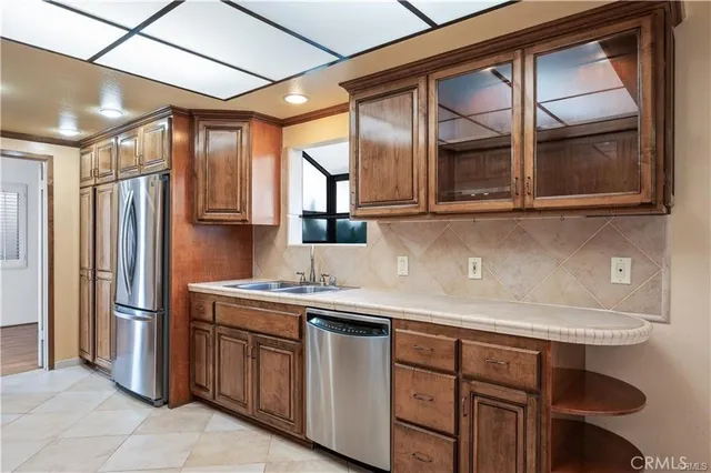 a kitchen with stainless steel appliances granite countertop a sink and a refrigerator
