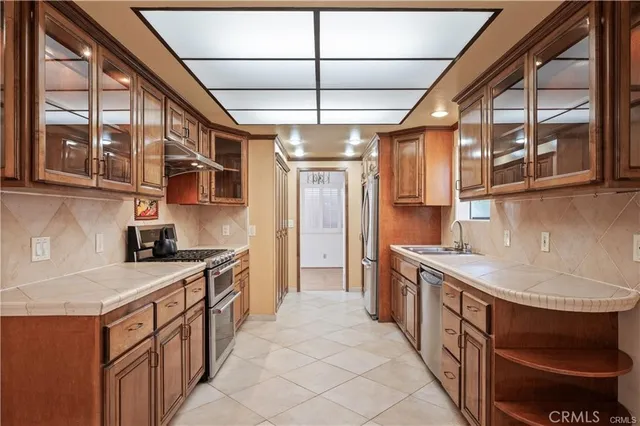 a kitchen with stainless steel appliances granite countertop a stove a sink and a refrigerator