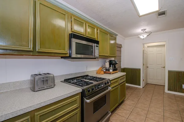 a kitchen with stainless steel appliances granite countertop a stove a microwave and a sink