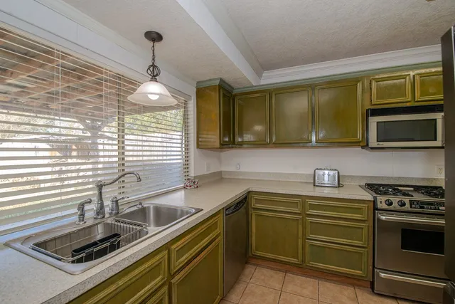 a kitchen with a sink appliances and cabinets