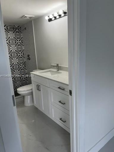 18344 Northwest 68th Avenue, Unit F Hialeah, FL 33015 - Photo 14 of 14 a bathroom with a granite countertop toilet and a sink