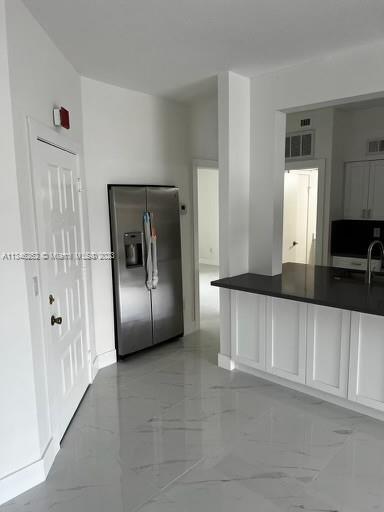 18344 Northwest 68th Avenue, Unit F Hialeah, FL 33015 - Photo 4 of 14 a view of a refrigerator in kitchen and an empty room