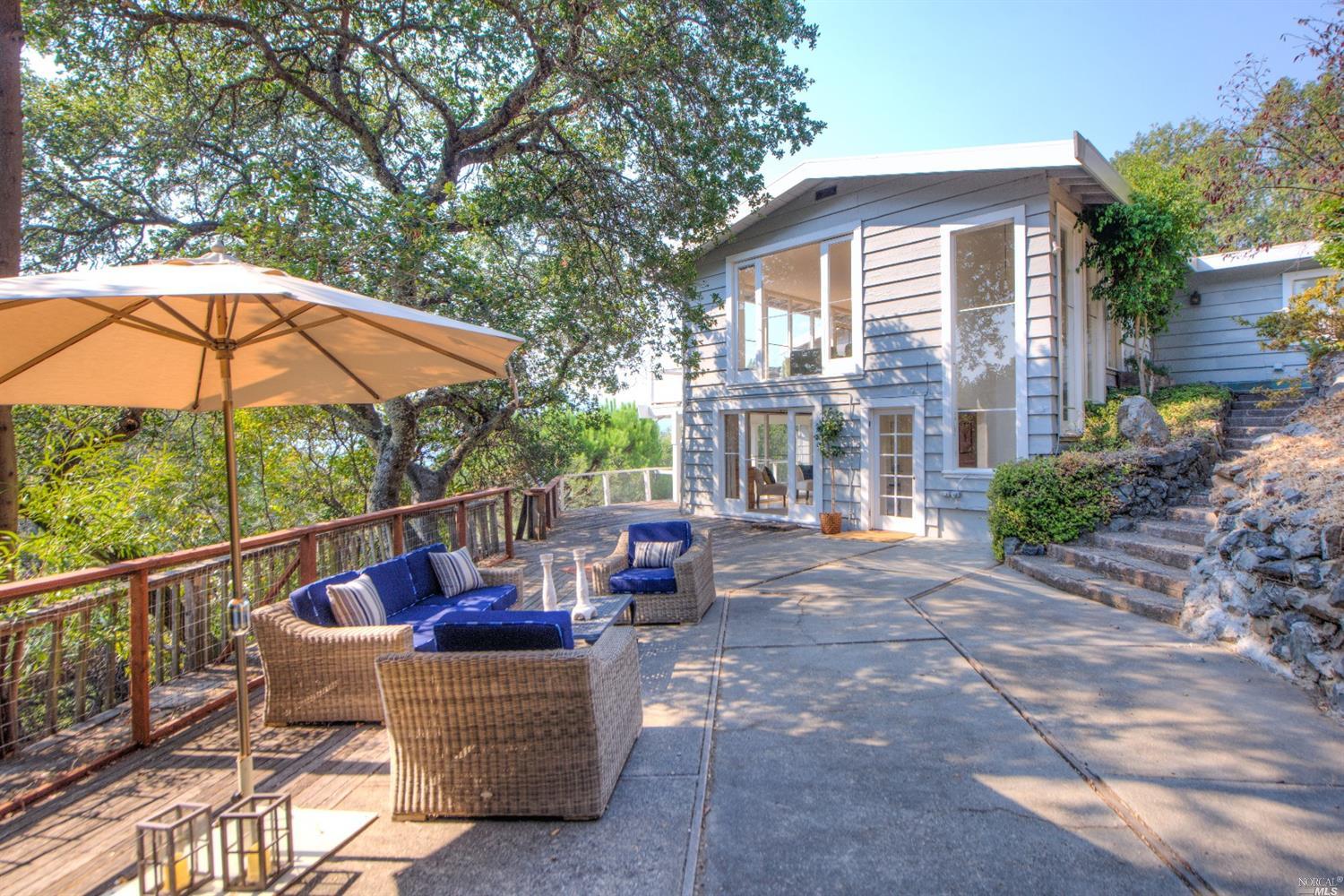 11 Morrison Road Ross, CA 94957 - Photo 1 of 1 a view of a patio with couches table and chairs under an umbrella