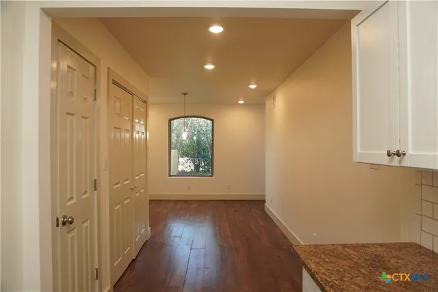 a view of hallway with wooden floor and front door