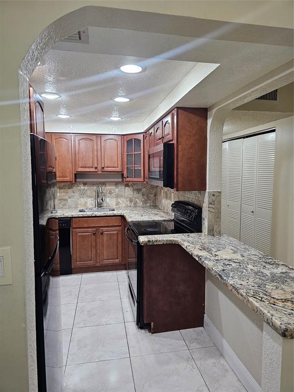 3720 North Pine Island Road, Unit 428 Sunrise, FL 33351 - Photo 16 of 22 a kitchen with a stove sink and cabinets