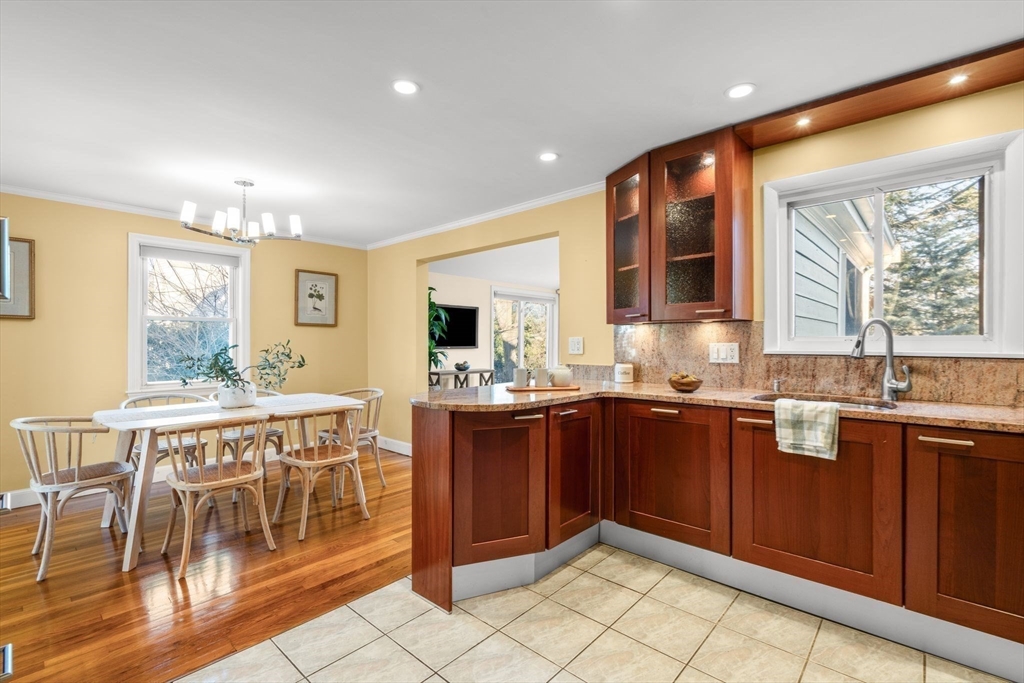 512 Appleton Street Arlington, MA 02476 - Photo 12 of 42 a kitchen with stainless steel appliances granite countertop wooden cabinets a dining table and chairs