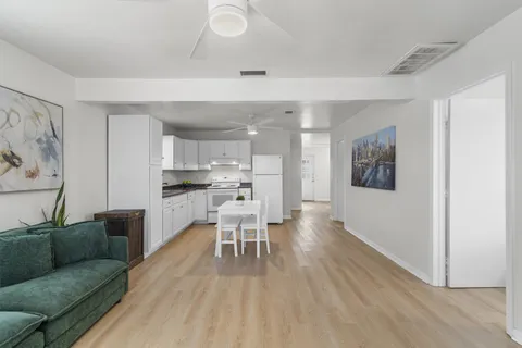 a living room with furniture and a dining table with kitchen view