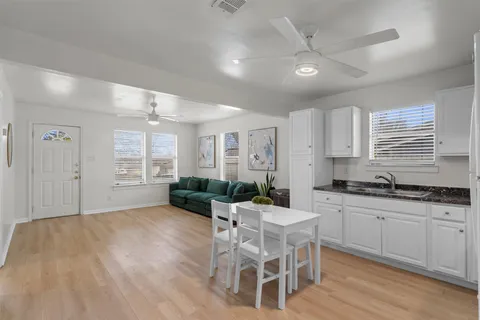 a kitchen with granite countertop a sink cabinets and wooden floor