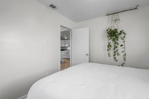 a bedroom with a bed and a potted plant