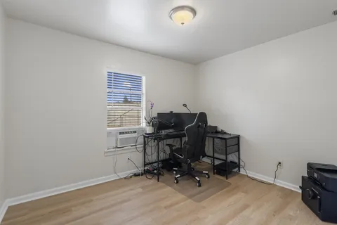a view of workspace with wooden floor and a window