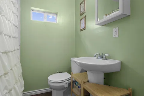 a bathroom with sink a toilet and mirror