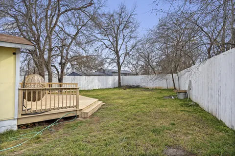 a view of backyard with wooden fence