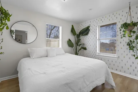 a bedroom with a bed mirror and a window