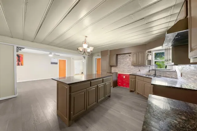 a bathroom with a granite countertop sink a refrigerator and cabinets