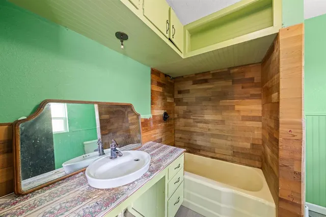 a view of an empty room with window and hardwood