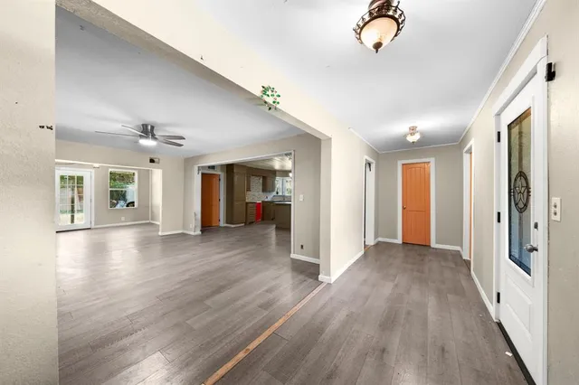 a view of a big room with wooden floor and windows