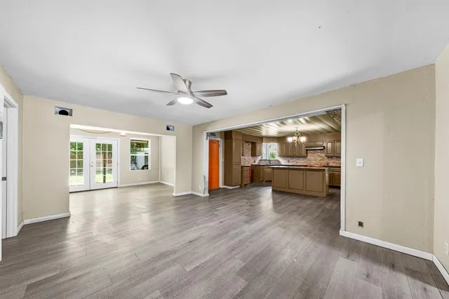 a view of an empty room with window and wooden floor