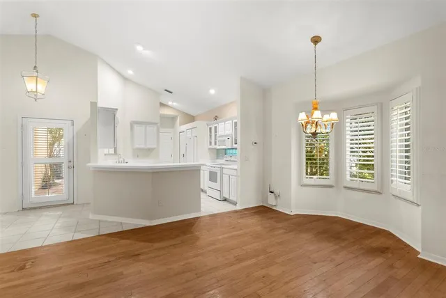 a view of an empty room with a window and chandelier