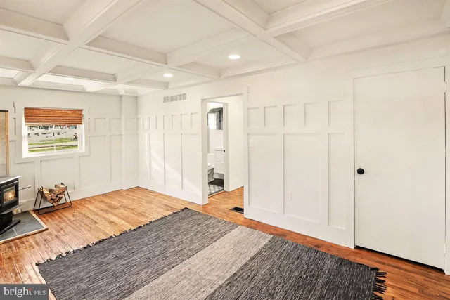 a view of a livingroom with wooden floor and a fireplace