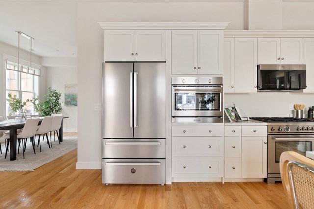 a kitchen with cabinets wooden floor and stainless steel appliances