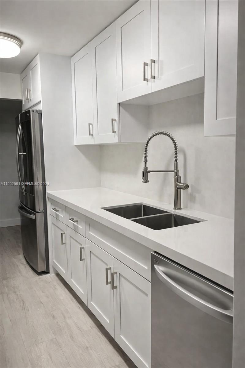 1703 Southwest 131st Pl Circle South Miami, FL 33175 - Photo 12 of 36 a kitchen with white cabinets and stainless steel appliances