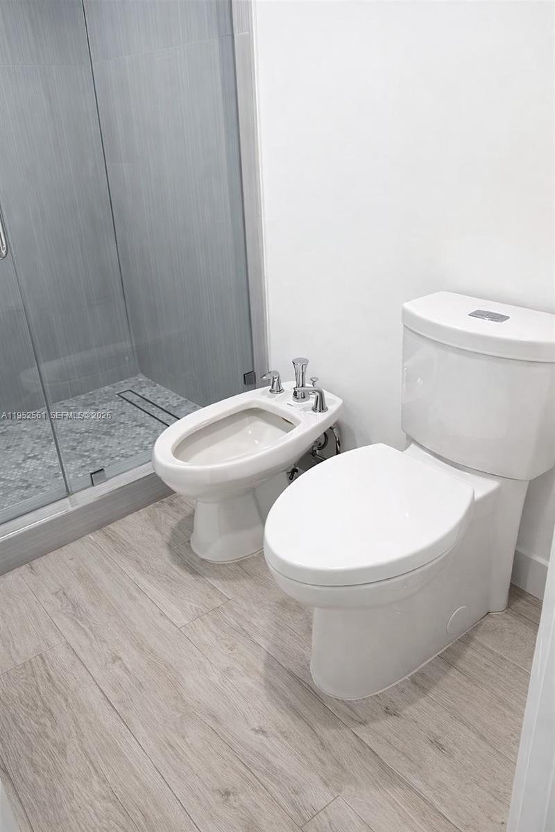 1703 Southwest 131st Pl Circle South Miami, FL 33175 - Photo 28 of 36 a white toilet sitting next to a bathroom sink and vanity