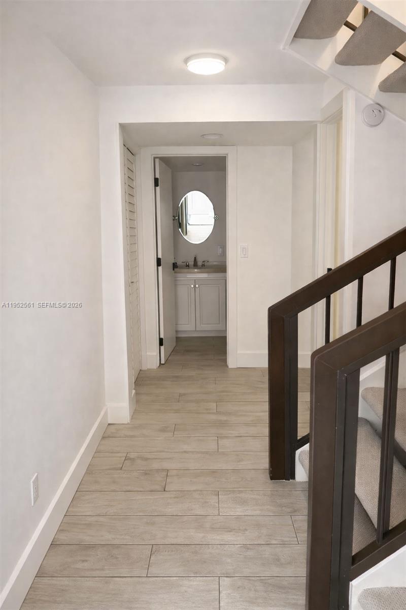 1703 Southwest 131st Pl Circle South Miami, FL 33175 - Photo 6 of 36 a view of a hallway with wooden floor and staircase