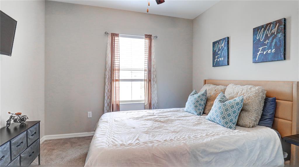 31632 Blue Passing Loop Wesley Chapel, FL 33545 - Photo 37 of 48 a large bed in a bedroom next to a window