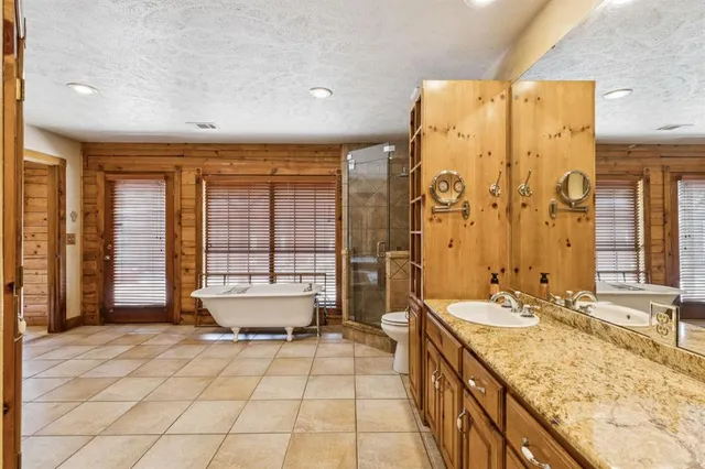 a spacious bathroom with a granite countertop sink a toilet and shower
