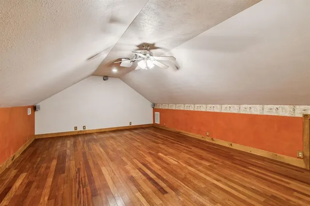 a view of a room with wooden floor and fan