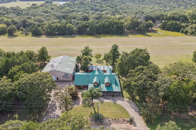an aerial view of a house with outdoor space and lake view