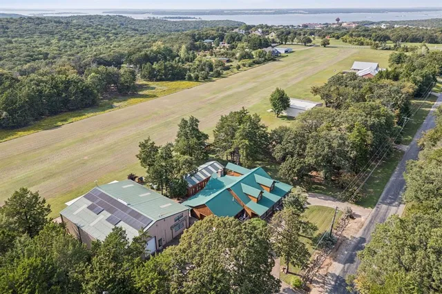 an aerial view of residential houses with outdoor space and trees