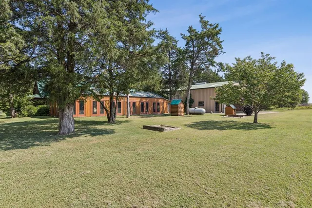 a view of a house with backyard and sitting area