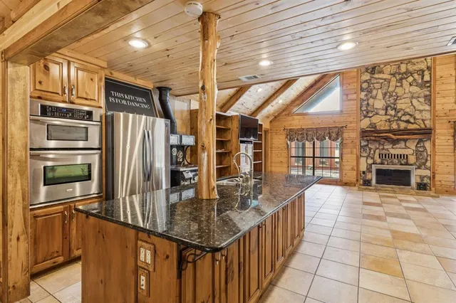 a kitchen with stainless steel appliances granite countertop a refrigerator a oven and a sink