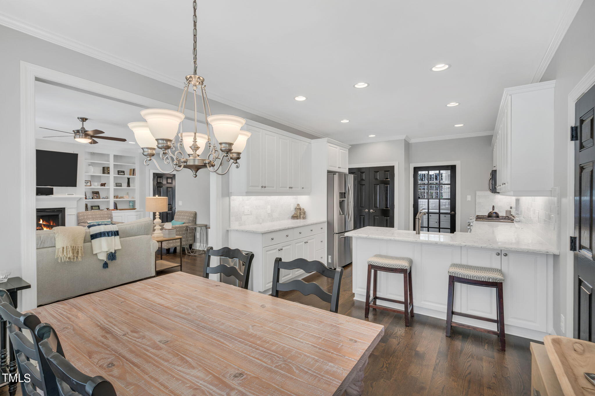 4301 Sprague Road Raleigh, NC 27613 - Photo 14 of 46 a kitchen with stainless steel appliances kitchen island granite countertop a dining table chairs and white cabinets