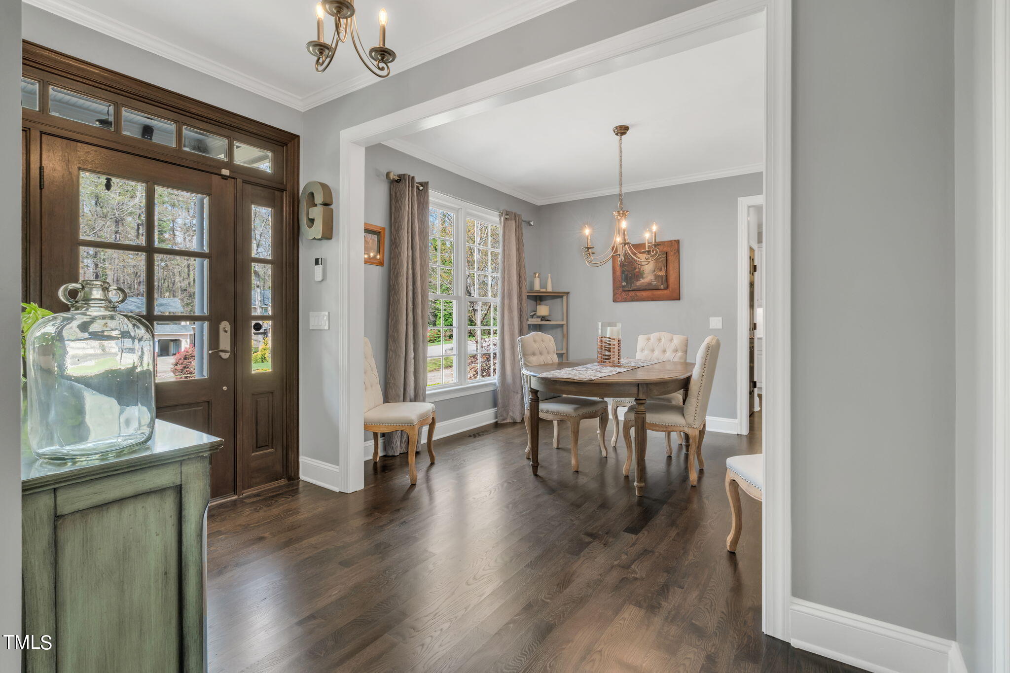 4301 Sprague Road Raleigh, NC 27613 - Photo 19 of 46 a dining room with wooden floor a chandelier a glass table and chairs