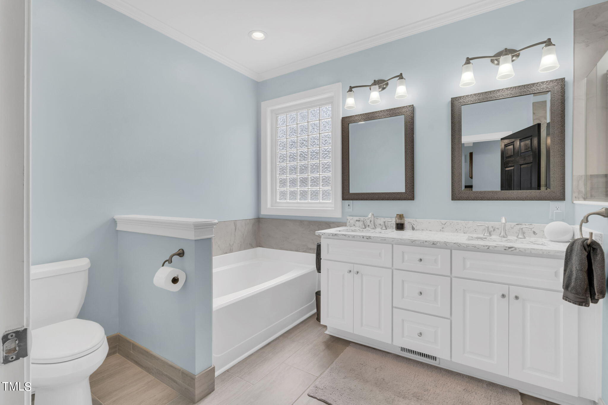 4301 Sprague Road Raleigh, NC 27613 - Photo 25 of 46 a bathroom with a double vanity sink toilet mirror and bathtub