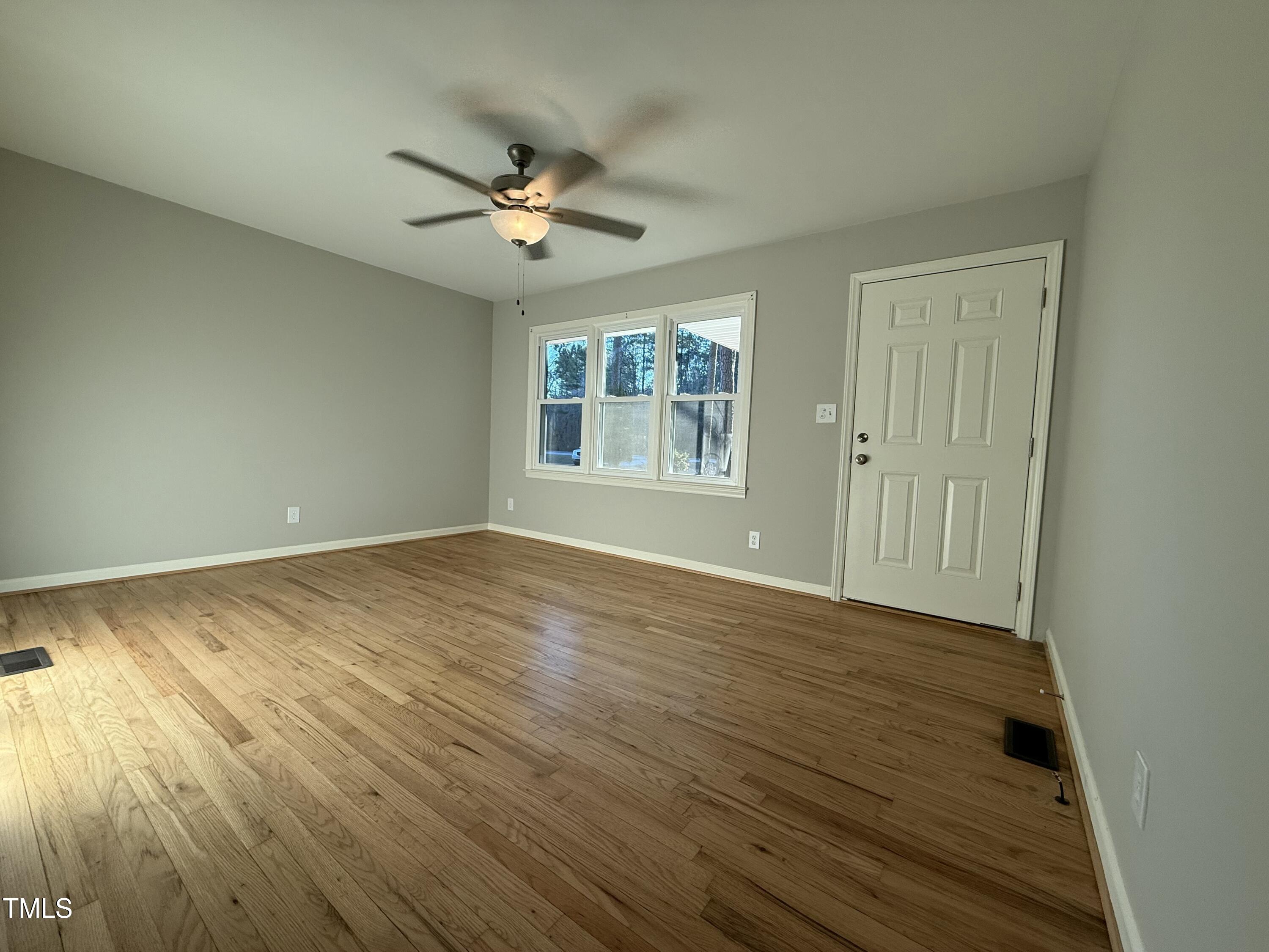 640 Crocker Road Smithfield, NC 27577 - Photo 6 of 28 a view of empty room with wooden floor and fan