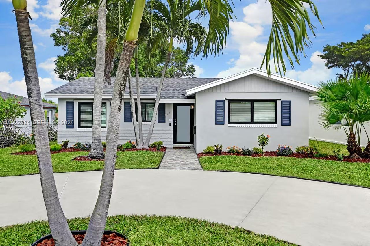 945 Sunset Road, Unit 1 West Palm Beach, FL 33401 - Photo 2 of 20 a front view of a house with a yard and garage