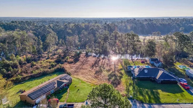 an aerial view of a house with a yard and lake view