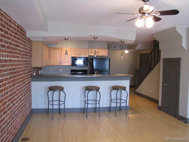 232 Broadway, Unit 2 Denver, CO 80203 - Photo 4 of 12 a kitchen with stainless steel appliances a table chairs refrigerator a sink and dishwasher