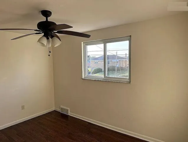 a view of a small space with wooden floor and windows