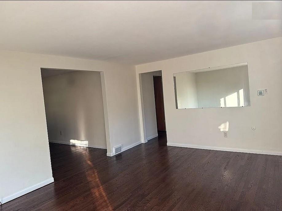 115 Starling Drive McKees Rocks, PA 15136 - Photo 3 of 12 an empty room with wooden floor and mirror
