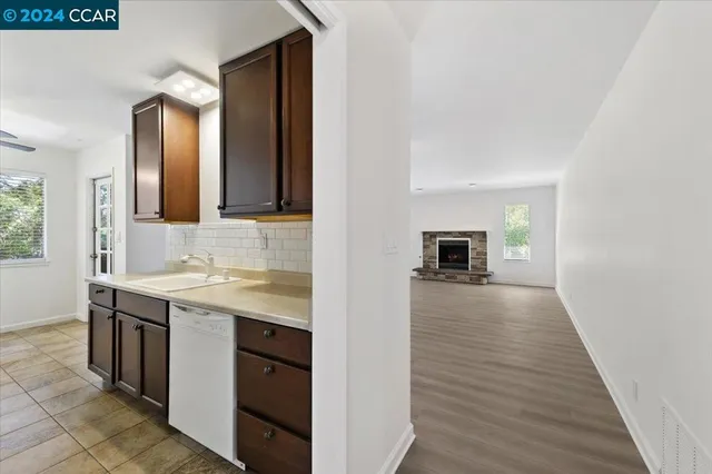 a view of empty room with wooden floor and fireplace