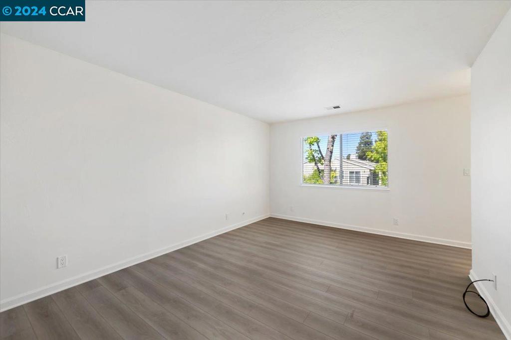 1050 Wesley Court Walnut Creek, CA 94597 - Photo 19 of 32 an empty room with wooden floor and windows