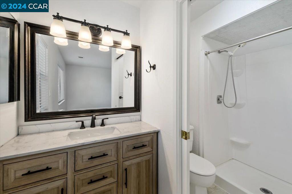 1050 Wesley Court Walnut Creek, CA 94597 - Photo 22 of 32 a bathroom with a granite countertop sink toilet and shower
